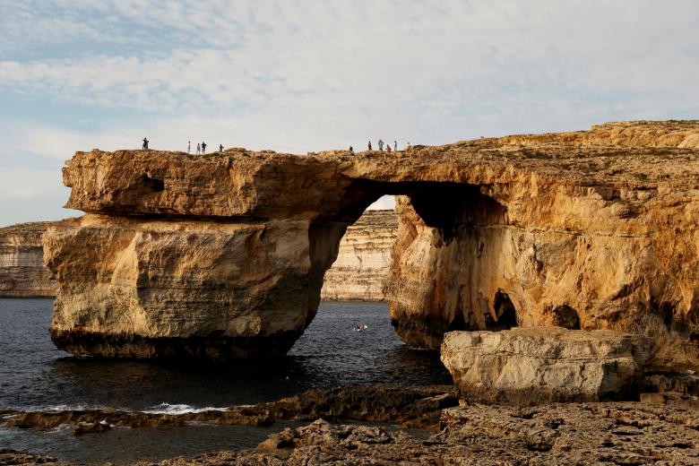 Tourists walk on the Azure Window, a 50 metre high rock arch, at Dwejra Point cliffs on the west coast of the Maltese island of Gozo September 23, 2016. REUTERS/Darrin Zammit Lupi/Files