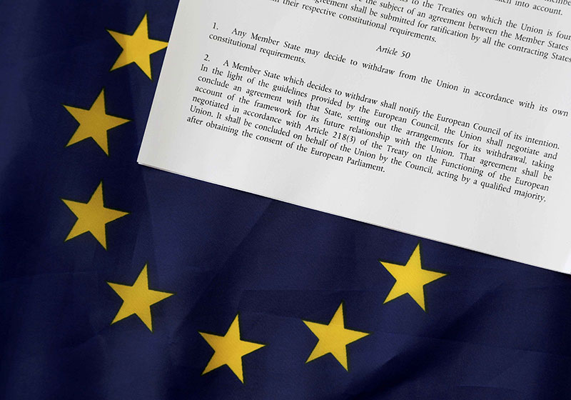 Article 50 of the EU's Lisbon Treaty that deals with the mechanism for departure is pictured with an EU flag following Britain's referendum results to leave the European Union, in this photo illustration taken in Brussels, Belgium, on June 24, 2016. Photo: Reuters
