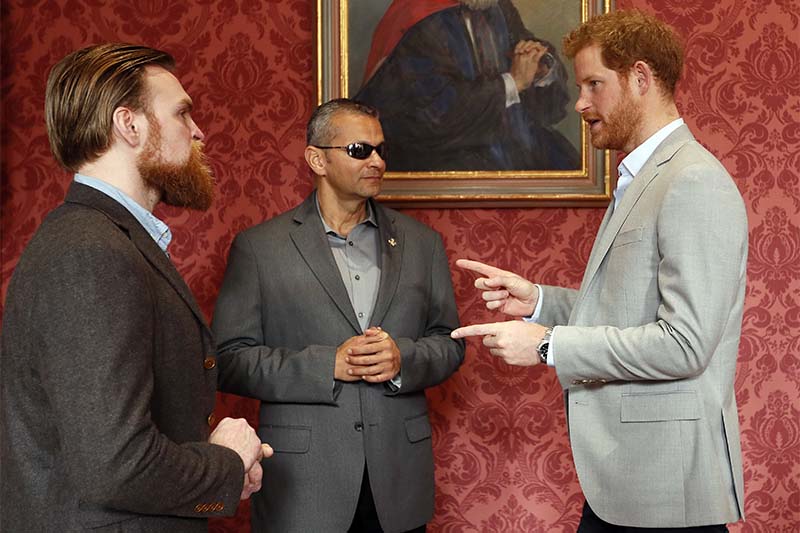 Britain's Prince Harry chats with US veteran Ivan Castro, centre, and UK veteran Karl Hinett, left, who will run the Boston and London Marathons for the Heads Together Campaign, after he attended a conference at King's College in London, on Thursday, March 16, 2017. Photo: AP