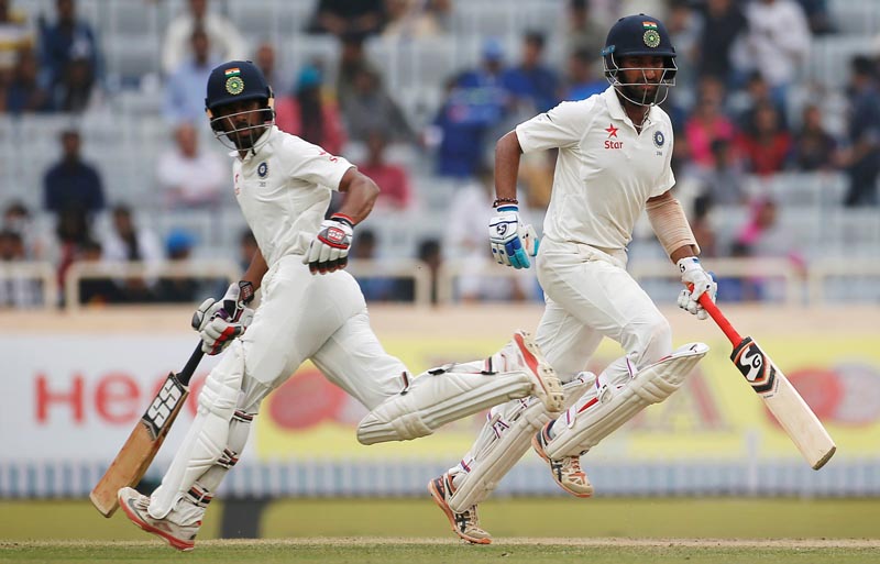 India's Cheteshwar Pujara (R) and Wriddhiman Saha run between the wickets. Photo: Reuters