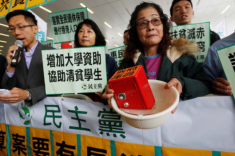 A protester carries a safe in water to mock the government's fiscal policy before the release of the annual budget report in Hong Kong, China on February 22, 2017. Photo: Reuters
