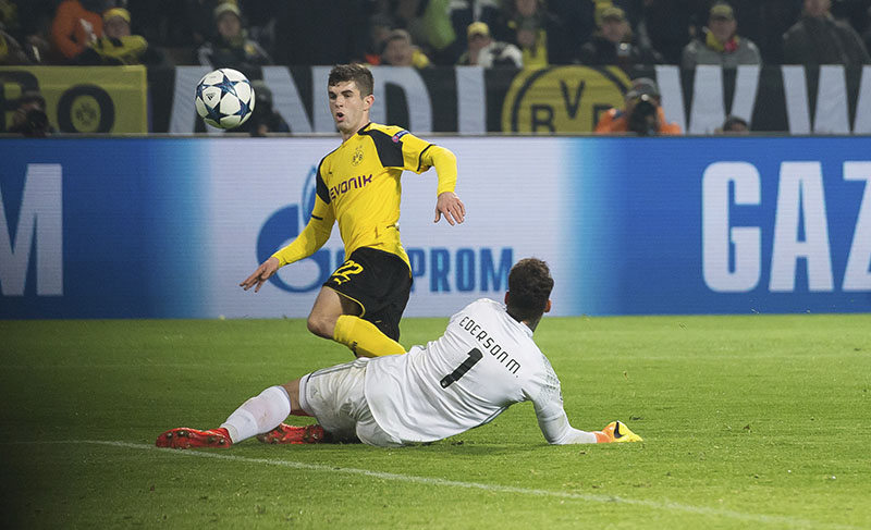 Dortmund's Christian Pulisic (left) scores his side's second goal past Benfica goalkeeper Ederson (right) during the Champions League round of 16, second leg, soccer match between Borussia Dortmund and Benfica in Dortmund, Germany, on Wednesday, March 8, 2017. Photo: Guido Kirchner/dpa via AP