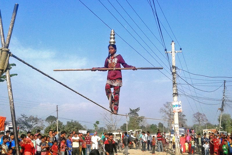 A circus member is seen demonstrating her skills of walking along a rope at Jhalari of Kanchanpur district, on Friday, March 17, 2017. Photo: RSS