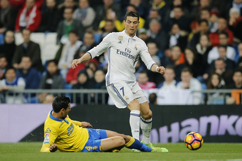 Real Madrid's Cristiano Ronaldo, right, is tackled by Las Palmas Vicente Gomez during a Spanish La Liga soccer match between Real Madrid and Las Palmas at the Santiago Bernabeu stadium in Madrid, Spain, Wednesday March 1, 2017. Photo: AP