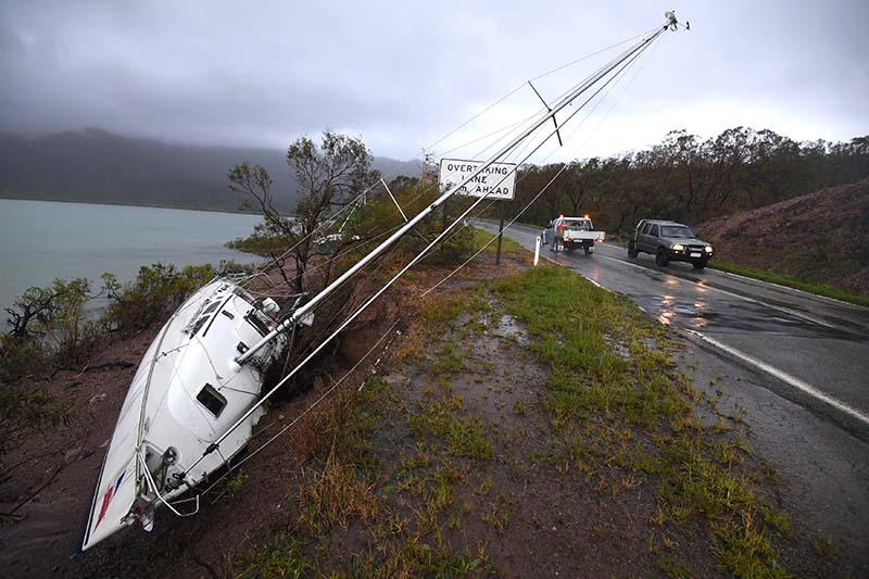 A yacht lies beside a road after Cyclone Debbie hit the northern Queensland town of Airlie Beach, located south of Townsville in Australia, on March 29, 2017. Photo: AAP via Reuters