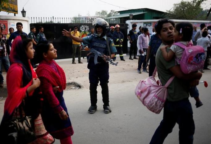 A security personnel directs people to walk on different way in front of a makeshift camp of Rapid Action Battalion (RAB) after an unidentified suicide bomber died in the camp in Dhaka, Bangladesh, March 17, 2017. REUTERS/Mohammad Ponir Hossain