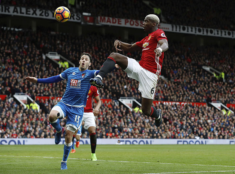 AFC Bournemouth's Adam Smith (left) and Manchester United's Paul Pogba battle for the ball during their English Premier League soccer match at Old Trafford, Manchester, England, on Saturday, March 4, 2017. Photo: Martin Rickett/PA via AP