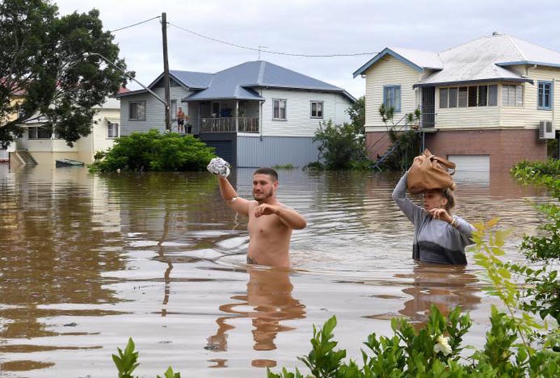 Local residents wade through floodwaters near their homes in the northern New South Wales town of Lismore, Australia, March 31, 2017 after heavy rains associated with Cyclone Debbie swelled rivers to record heights across the region. Photo: Reuters