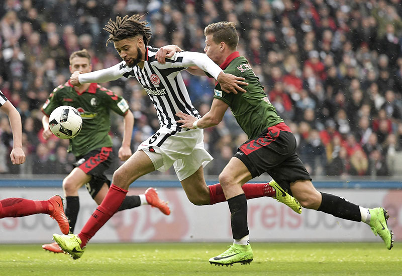 Frankfurt's Michael Hector, center, and Freiburg's Florian Niederlechner, right, challenge for the ball  during the Bundesliga soccer match between Eintracht Frankfurt and SC Freiburg at the Commerzbank Arena in Frankfurt  Germany, on Sunday, March 5, 2017. Photo: Thorsten Wagner/dpa via AP