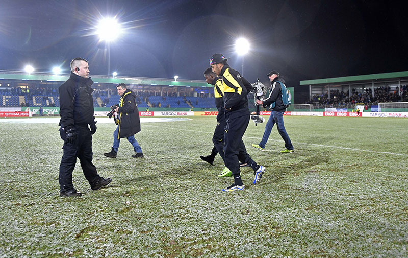 Dortmund's Pierre-Emerick Aubameyang and Ousmane Dembele leave the muddy pitch after the German Soccer Cup quarterfinal match between SF Lotte and Borussia Dortmund was cancelled in Lotte, Germany, on Tuesday, February 28, 2017. Due to heavy rain before the match, the pitch was unplayable. Photo: AP