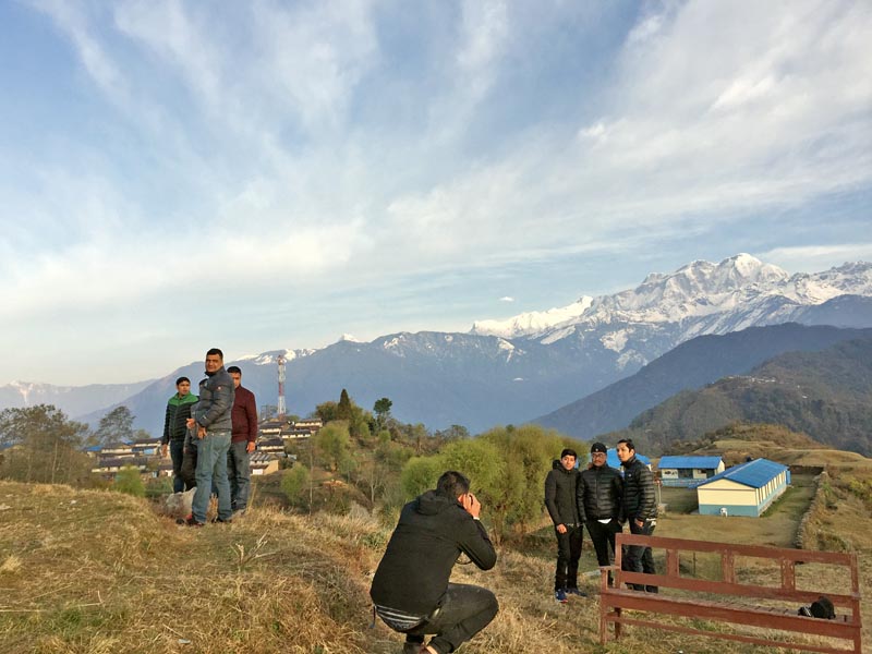 Tourists pose for a photo against the backdrop of a snow-covered mountain range at Ghalegaun in Lamjung district, on Wednesday, March 15, 2017. Photo: RSS