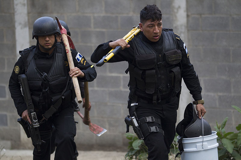Police carry tools, including axes and a large plier, to use in an operation that aims to rescue four jail guards who were taken in the midst of a prison riot at the Centro Correccional Etapa II reformatory in San Jose Pinula, Guatemala, on Monday, March 20, 2017. Photo: AP