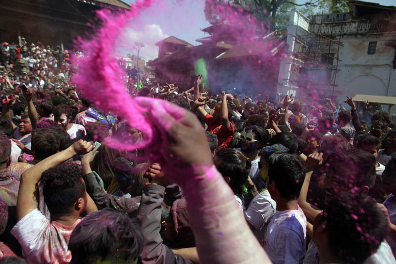 A man throws colored powder as people gather for Holi festivities at the Basantapur Durbar Square in Kathmandu, Nepal, Sunday, March 12, 2017. Photo: AP
