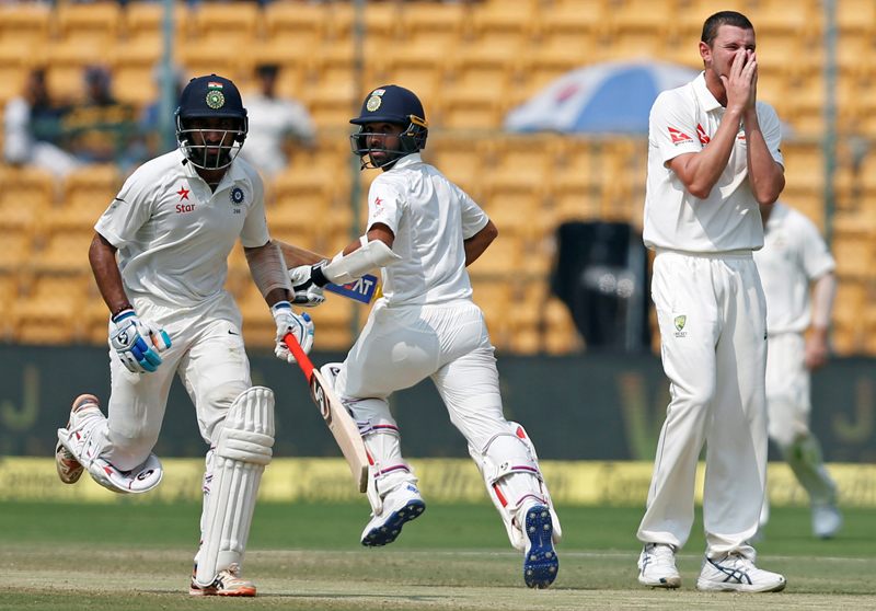 India's Cheteshwar Pujara and Ajinkya Rahane run between the wickets as Australia's Josh Hazlewood looks on. Photo: Reuters