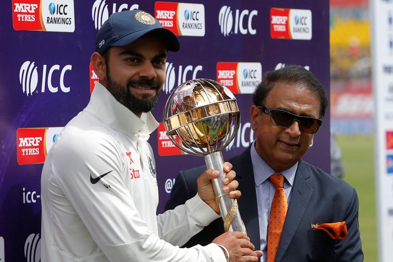India's Virat Kohli receives the ICC Test Mace from former Indian cricket player Sunil Gavaskar (R) after India won the test series against Australia. Photo: Reuters