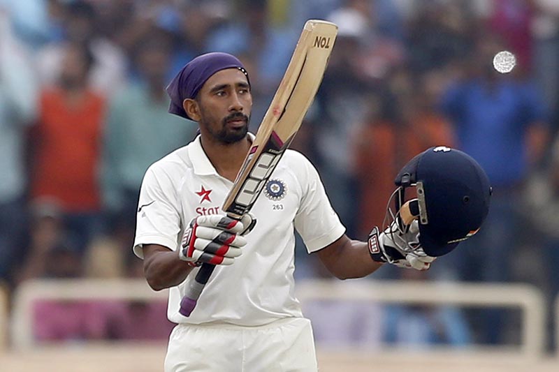 India's Wriddhiman Saha raises his bat and helmet to celebrate scoring a hundred during the fourth day of their third test cricket match against Australia in Ranchi, India, Sunday, March 19, 2017. Photo: AP