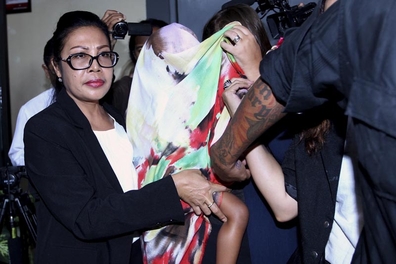 Security guards and a lawyer escort Stella Schaefer, center, covered with a scarf, the two-year-old daughter of Heather Mack, an American woman convicted in her mother's death in Indonesia, as the baby leaves Kerobokan Prison with Australian Balinese woman Oshar Putu Melody Suartama, also partially covered by the scarf, who will take care of her until her mother is released, in Bali, Indonesia Friday, March 17, 2017. Photo: AP