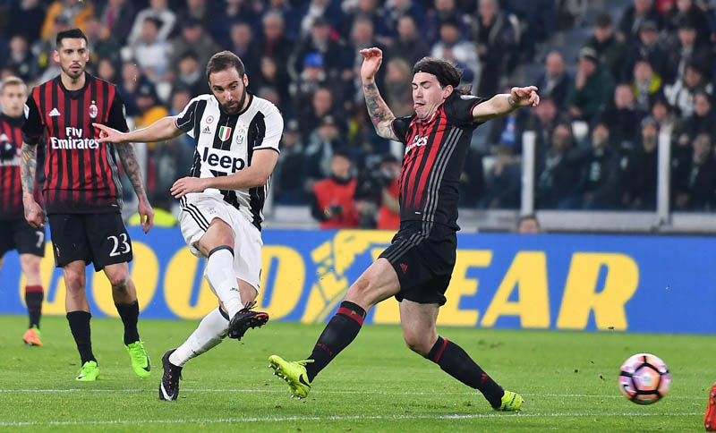 Juventus' Gonzalo Higuain, left, and Milan's Alessio Romagnoli vie for the ball during the Italian Serie A soccer match between Juventus and Milan at the Juventus stadium in Turin, Italy, Friday, March 10, 2017. Photo: AP