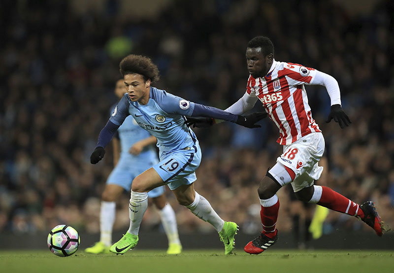 Manchester City's Leroy Sane (left) and Stoke City's Mame Biram Diouf battle for the ball during their English Premier League soccer match at the Etihad Stadium, Manchester, England, on Wednesday, March 8, 2017. Photo: Mike Egerton/PA via AP