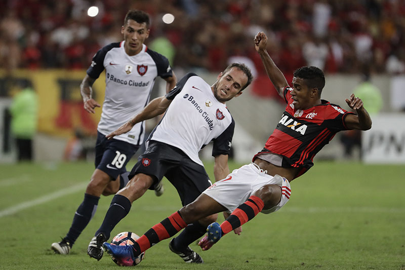 Gabriel, of Brazil's Flamengo, right, fights for the ball with Fernando Belluschi, of Argentina's San Lorenzo, during a Copa Libertadores soccer match at Maracana stadium in Rio de Janeiro, Brazil, on Wednesday, March 8, 2017. Photo: AP