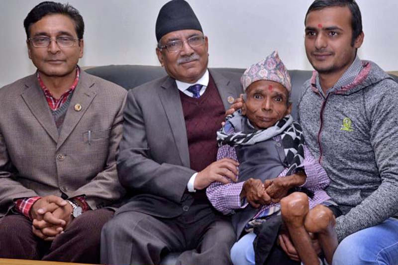 Prime Minister Pushpa Kamal Dahal (second from left) poses for a photo with Krishna Prasad Paudel, who claims to be the shortest teacher alive, at his residence, in Baluwatar on Tuesday, March 22, 2017. Photo Courtesy: PM's Secretariat