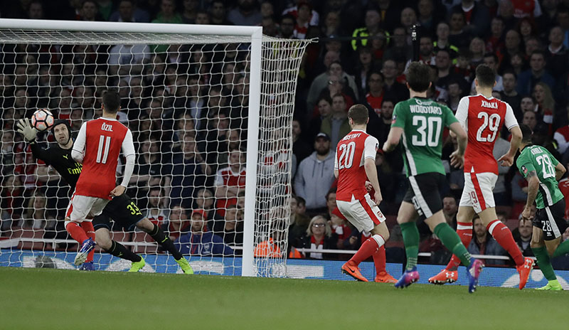 Arsenal's goalkeeper Petr Cech, left, looks to block a shot on goal during the English FA Cup quarterfinal soccer match between Arsenal and Lincoln City at the Emirates stadium in London, on Saturday, March 11, 2017. Photo: AP