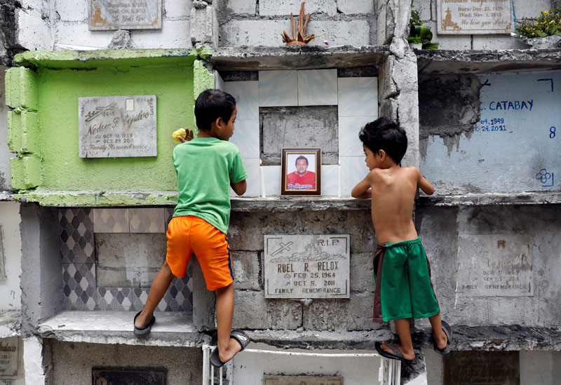 Boys look at the tomb of Michael Almeda, who was among those allegedly killed by the Bonnet Gang, in more than 60 drug-related vigilante killings in the town of Pateros, Metro Manila, Philippines, on March 15, 2017. Photo: Reuters