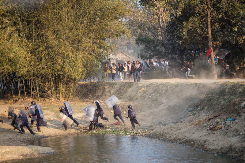 Security personnel run for cover as Madhesi activists hurl stones at them in Saptari District, Nepal March 6, 2017. Photo: Reuters
