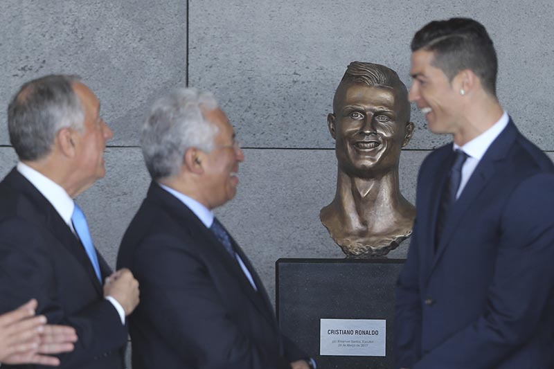 Portuguese President Marcelo Rebelo de Sousa (left), Portuguese Prime Minister Antonio Costa (2nd left) and Real Madrid's Cristiano Ronaldo stand next to a bust of the player at the Madeira international airport outside Funchal, the capital of Madeira island, Portugal, on Wednesday, March 29, 2017. Photo: AP