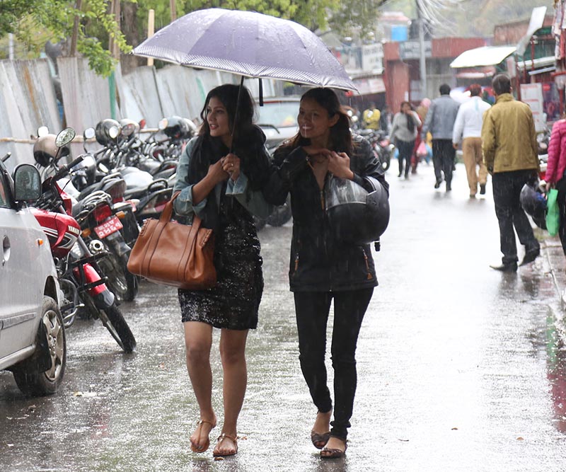 Two women walk down the street under an umbrella while it rains in Kathmandu, on Saturday, March 18, 2017. Photo: RSS