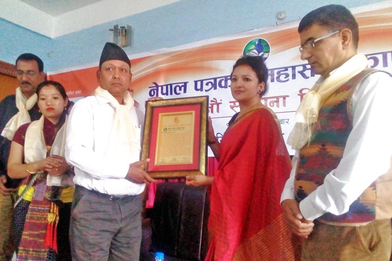 A local journalist is being felicitated by the Jhapa Chapter of Federation of Nepali Journalists on the occasion of 62nd anniversary of the Federation, in Biratamod, on Wednesday, March 29, 2017. Photo: RSS