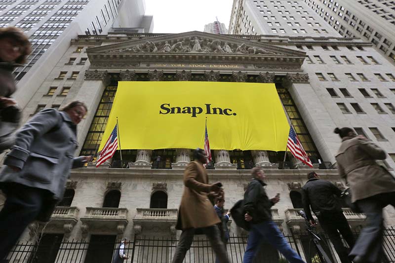 People pass by the New York Stock Exchange after the banner for the Snap Inc. IPO was raised on the building's facade, on Wednesday, March 1, 2017. Photo: AP