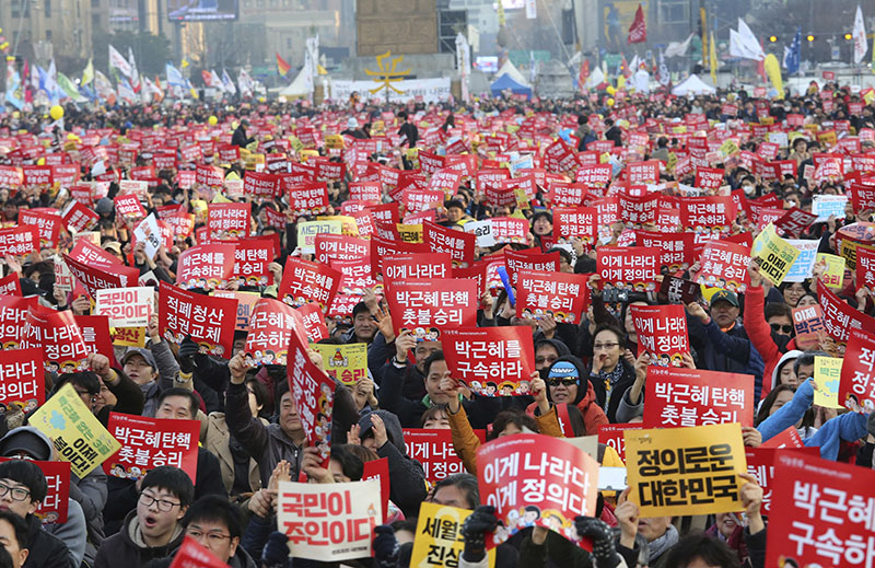 Protesters hold up cards during a rally calling for impeached President Park Geun-hye's arrest in Seoul, South Korea, on Saturday, March 11, 2017. Photo: AP