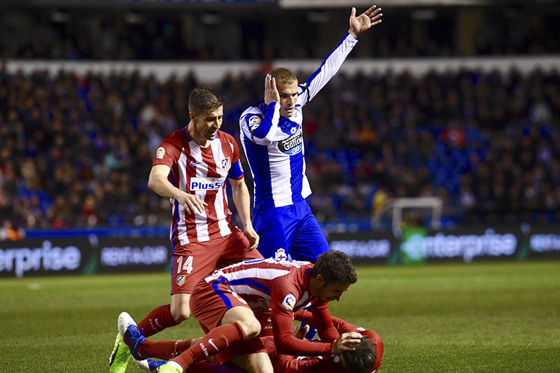 Atletico Madrid's Fernando Torres is helped by team mates as Deportivo La Coruna's Alex Bergantinos (top right) calls for help after they clashed with their heads during a La Liga soccer match at the Riazor stadium in La Coruna, Spain, on Thursday March 2, 2017. Photo: AP