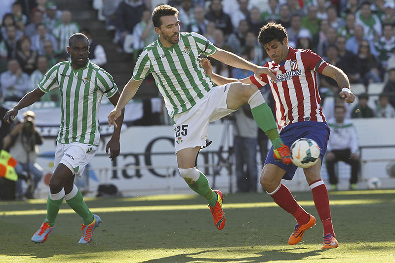 FILE - Betis' Jordi Figueras (centre), fights for the ball with Atletico de Madrid's Diego Costa (right) during their La Liga soccer match at the Benito Villamarin stadium, in Seville, Spain, on March 23, 2014. Photo: AP