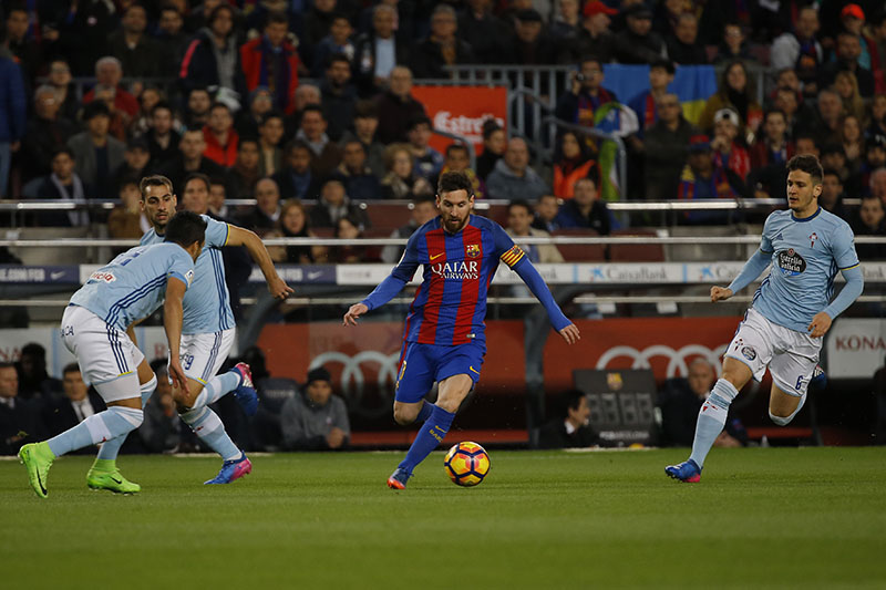 Barcelona's Lionel Messi (centre) runs with the ball past Celta's defenders during a Spanish La Liga soccer match between Barcelona and Celta at the Camp Nou stadium in Barcelona, on Saturday, March 4, 2017. Messi scored twice in Barcelona's 5-0 victory. Photo: AP