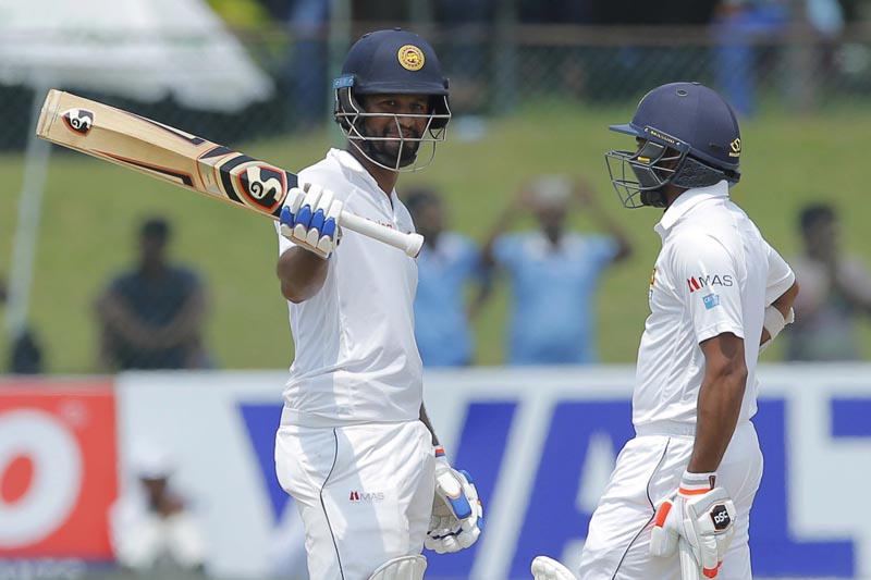 Sri Lanka's Dimuth Karunaratne celebrates scoring a century against Bangladesh as Niroshan Dickwella, right, watches on day four of their second test cricket match in Colombo, Sri Lanka, Saturday, March 18, 2017. Photo: AP