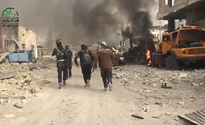 This frame grab from video provided on Tuesday March 21, 2017, by Ahrar al-Sham, Syrian militant group outlet that is consistent with independent AP reporting, shows fighters from Ahrar al-Sham militant group run next of a burn truck during a battle against the Syrian government forces, in an eastern neighborhood of Damascus, Syria. Photo: AP