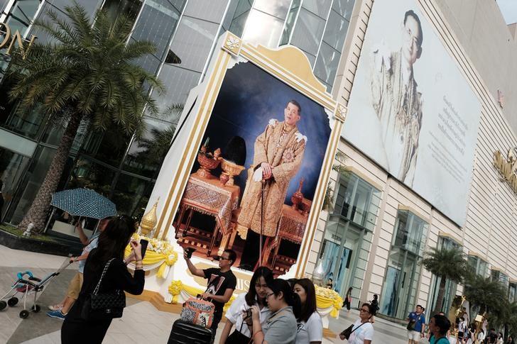 People walk past a portrait of Thailand's King Maha Vajiralongkorn Bodindradebayavarangkun and the late King Bhumibol Adulyadej at a department store in central Bangkok, Thailand, January 17, 2017. REUTERS/Athit Perawongmetha/Files