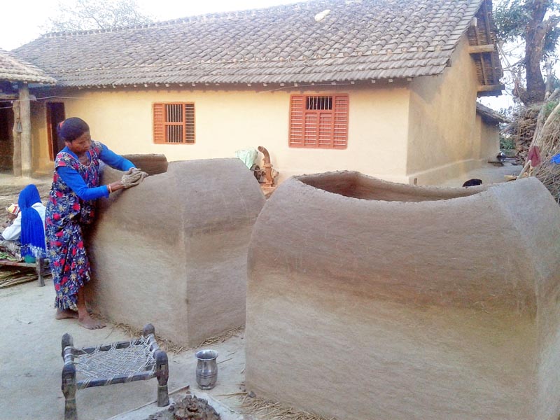 FILE - A woman from a Tharu community is seen making traditional containers out of mud to store food grains, in Kanchanpur district, on Wednesday, March 29, 2017. Photo: RSS