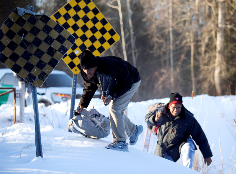 A man who claimed to be from Sudan climbs over a pile of snow as he and his family illegally cross the US-Canada border leading into Hemmingford, Quebec, Canada, on March 20, 2017. Photo: Reuters