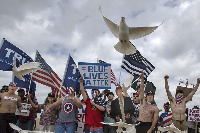US President Donald Trump supporters release doves during a march, in Huntington Beach, Southern California, on Saturday, March 25, 2017. Photo: The Orange County Register via AP)