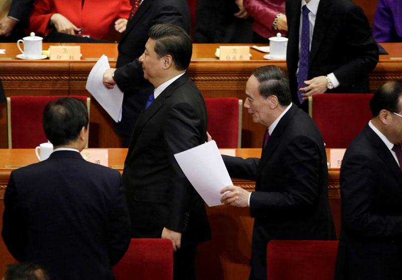 File - China's Politburo Standing Committee member Wang Qishan, the head of China's anti-corruption watchdog, talks to President Xi Jinping at the Great Hall of the People in Beijing, China, March 3, 2016. Photo: Reuters