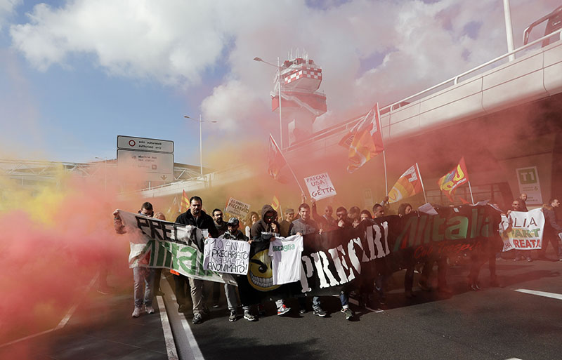 Demonstrators, including Italian airliner Alitalia's workers, march in front of Leonardo da Vinci International airport in Fiumicino, some 30 kilometers from Rome, on Thursday, Feb. 23, 2017. Photo: AP