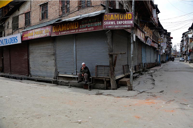 A Kashmiri man sits outside a closed shop during a strike in Srinagar, Indian controlled Kashmir, Sunday, April 2, 2017. Kashmiri separatists called for a strike Sunday to protest against the visit of Indian Prime Minister Narendra Modi to the disputed region. Photo: AP