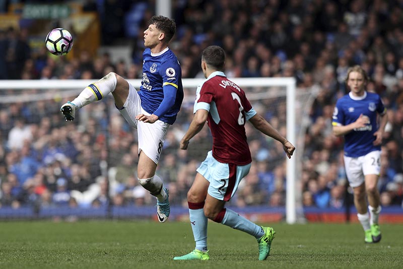 Everton's Ross Barkley (left) and Burnley's Matthew Lowton battle for the ball during their English Premier League soccer match at Goodison Park, Liverpool, England, on Saturday, April 15, 2017. Photo: Martin Rickett/PA via AP