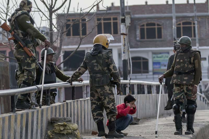 Indian paramilitary soldiers force a Kashmiri child to perform sit-ups while holding his ear lobes, a common elementary school punishment in India, before letting him go during a strike in Srinagar, Indian-controlled Kashmir on March 29, 2017. Photo: AP
