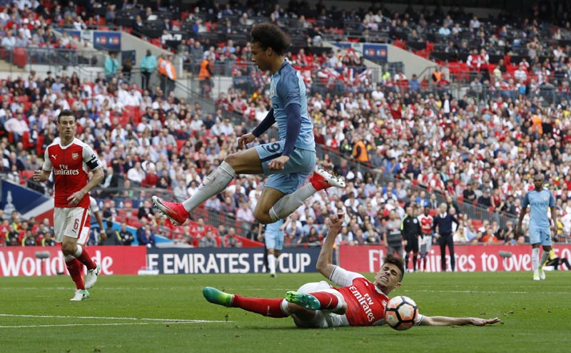 Manchester City's Leroy Sane in action with Arsenal's Gabriel Paulista. Photo: Reuters