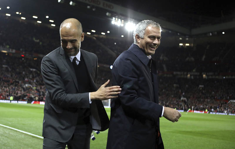 FILE - Manchester City's manager Pep Guardiola (left), and Manchester United's manager Jose Mourinho smile ahead of their English League Cup soccer match at Old Trafford stadium in Manchester, on Wednesday, October 26, 2016. Photo: AP