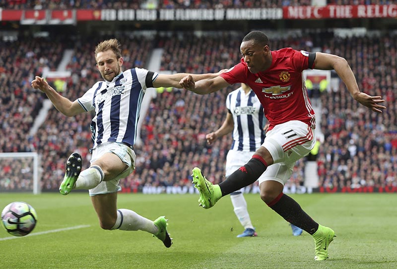 West Bromwich Albion's Craig Dawson )left), tries to block Manchester United's Anthony Martial during their English Premier League soccer match at Old Trafford in Manchester, England, on Saturday April 1, 2017. Photo: Martin Rickett/PA via AP